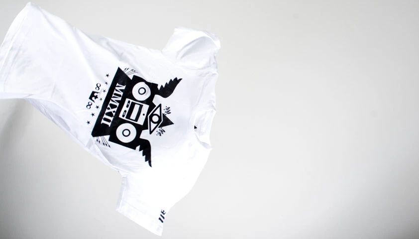 White t-shirt tossed in the air, printed with a black boombox and owl-wing design